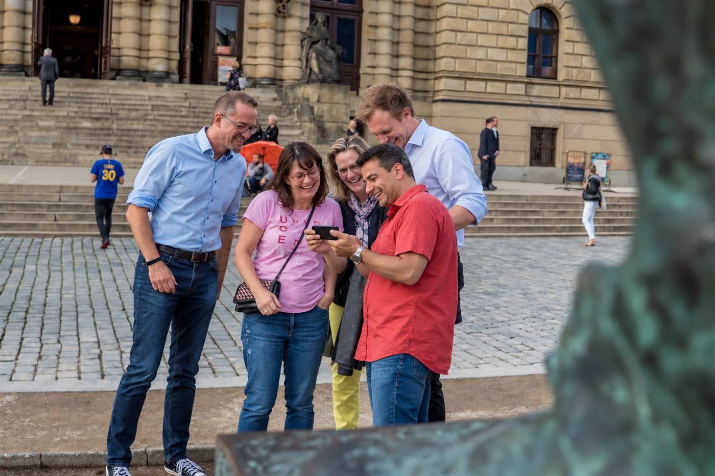 A team laughing over the game in front of the Rudolfinum