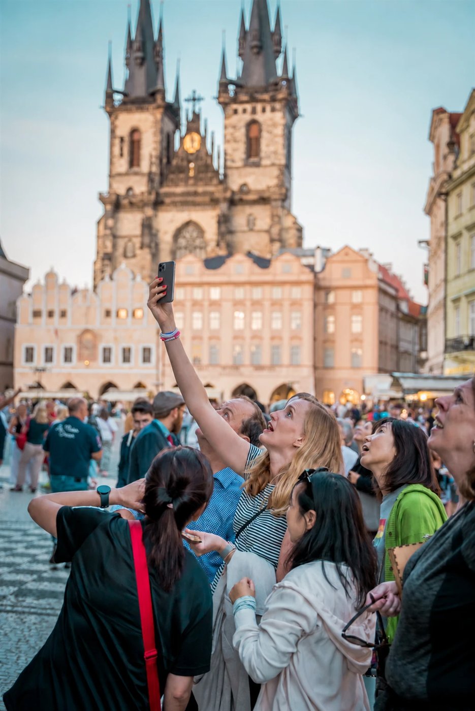 A player raises her phone in front of the Church of Our Lady before Týn