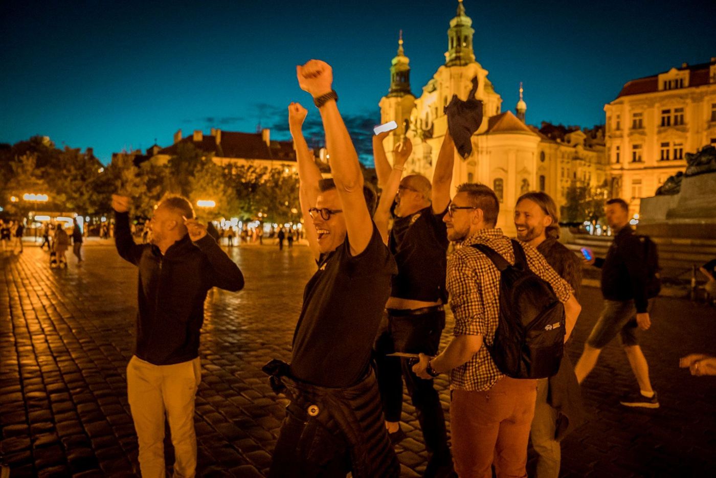 A team celebrating on Old Town Square at night