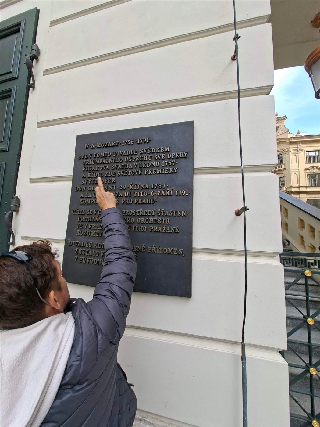 A player points to the Mozart plaque on the Estates Theatre