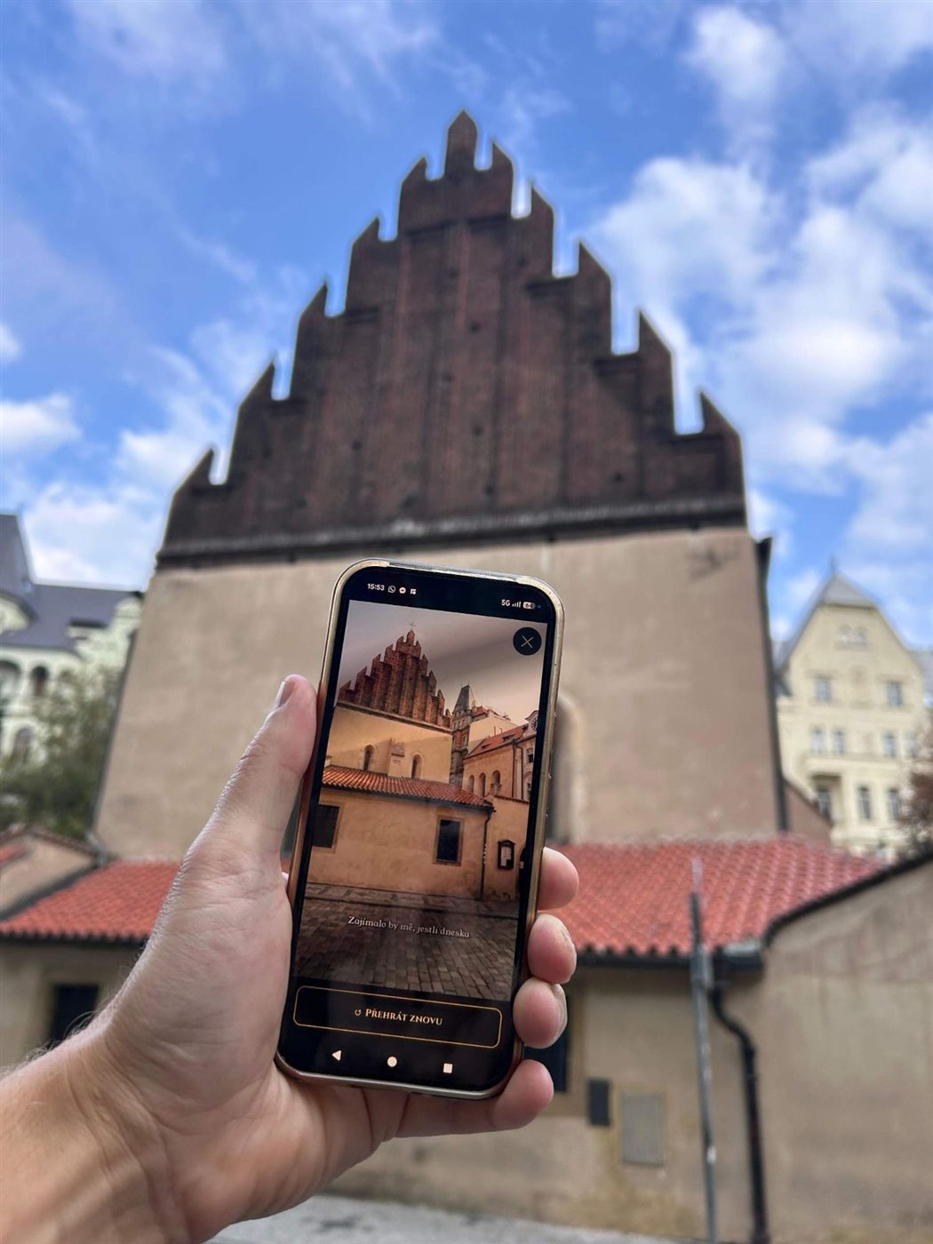 The Old-New Synagogue scene on a phone in front of the synagogue itself